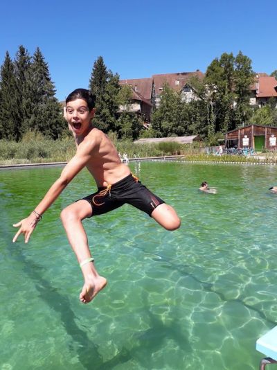 un enfant qui saute dans l'eau de la piscine