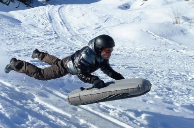 un homme qui descend la piste de luge en airboard